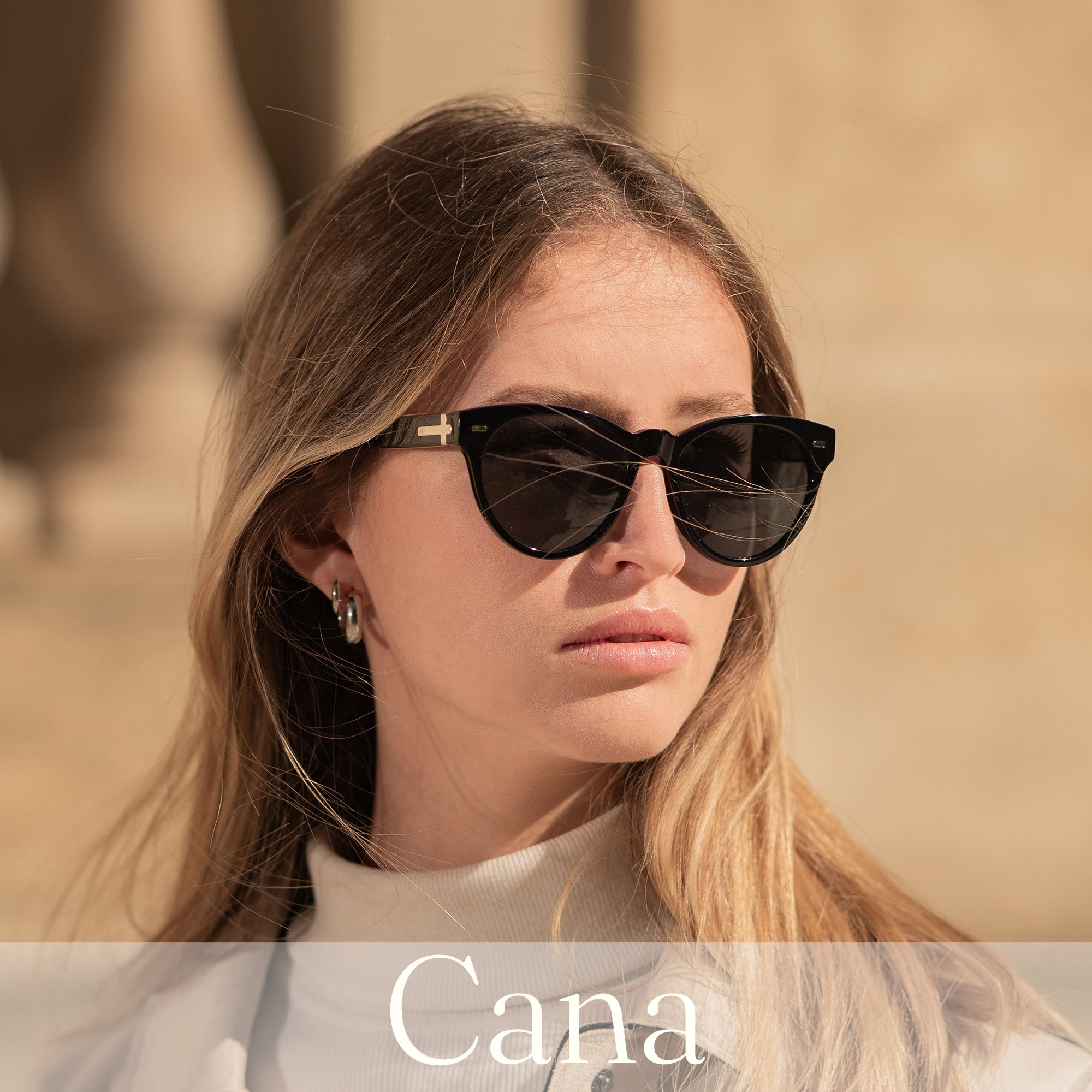 Woman wearing the Cana Sunglasses with a silver cross emblem